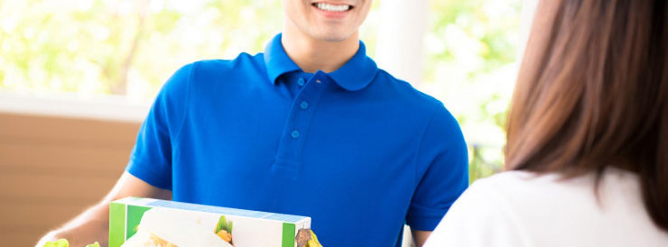 Delivery man delivering food to a woman at home