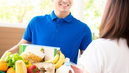 Delivery man delivering food to a woman at home