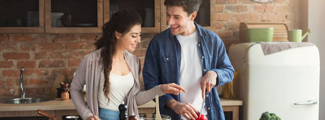 Happy couple cooking dinner together