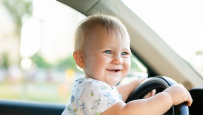 mignon-petit-bebe-garcon-conduisant-grosse-voiture-tenant-volant-souriant-impatient-interet_88194-963