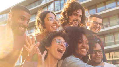 Joyful multiethnic friends taking funny group selfie