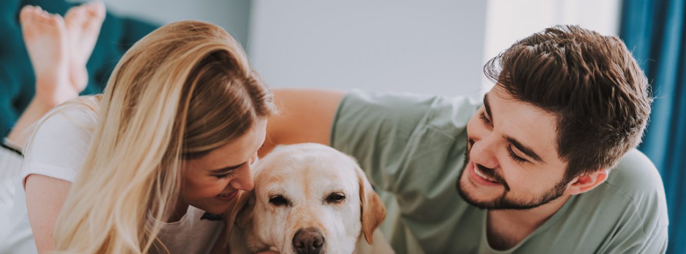 Joyful young couple resting with their dog