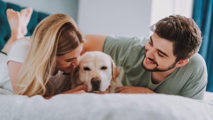 Joyful young couple resting with their dog