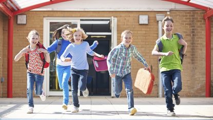 Schoolchildren Running Into Playground At End Of Class